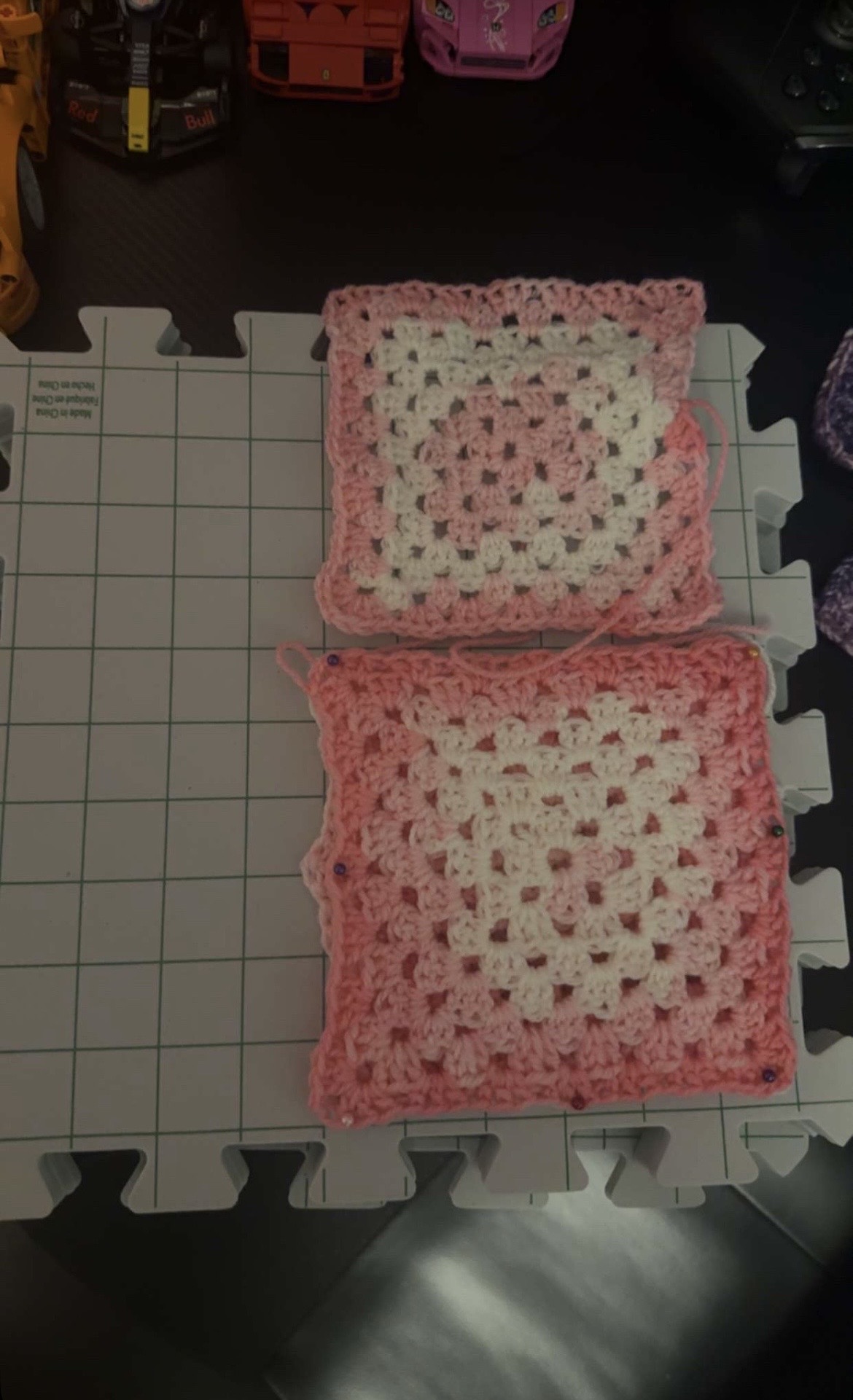 Pink and white granny squares being blocked for a crochet bag